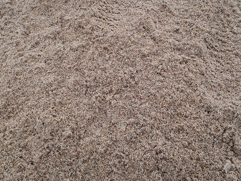 Hiekka: vaaleanruskeaa hiekkaa läheltä kuvattuna.