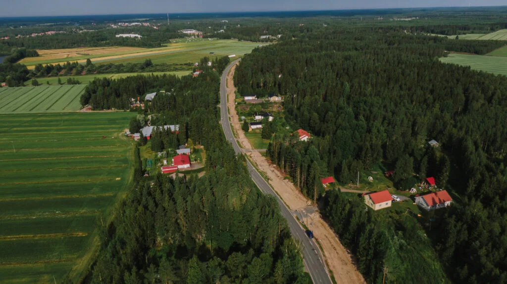Viherrakentaminen vaatii taitavat ammattilaisensa. Sen avulla tontille voidaan tehdä vaikka ja mitä. Heinäkuinen ilmakuva taajamasta lintuperpektiivissä. Hyvin hoidettuja peltoja ja omakotitalo sekä mäntymetsää..