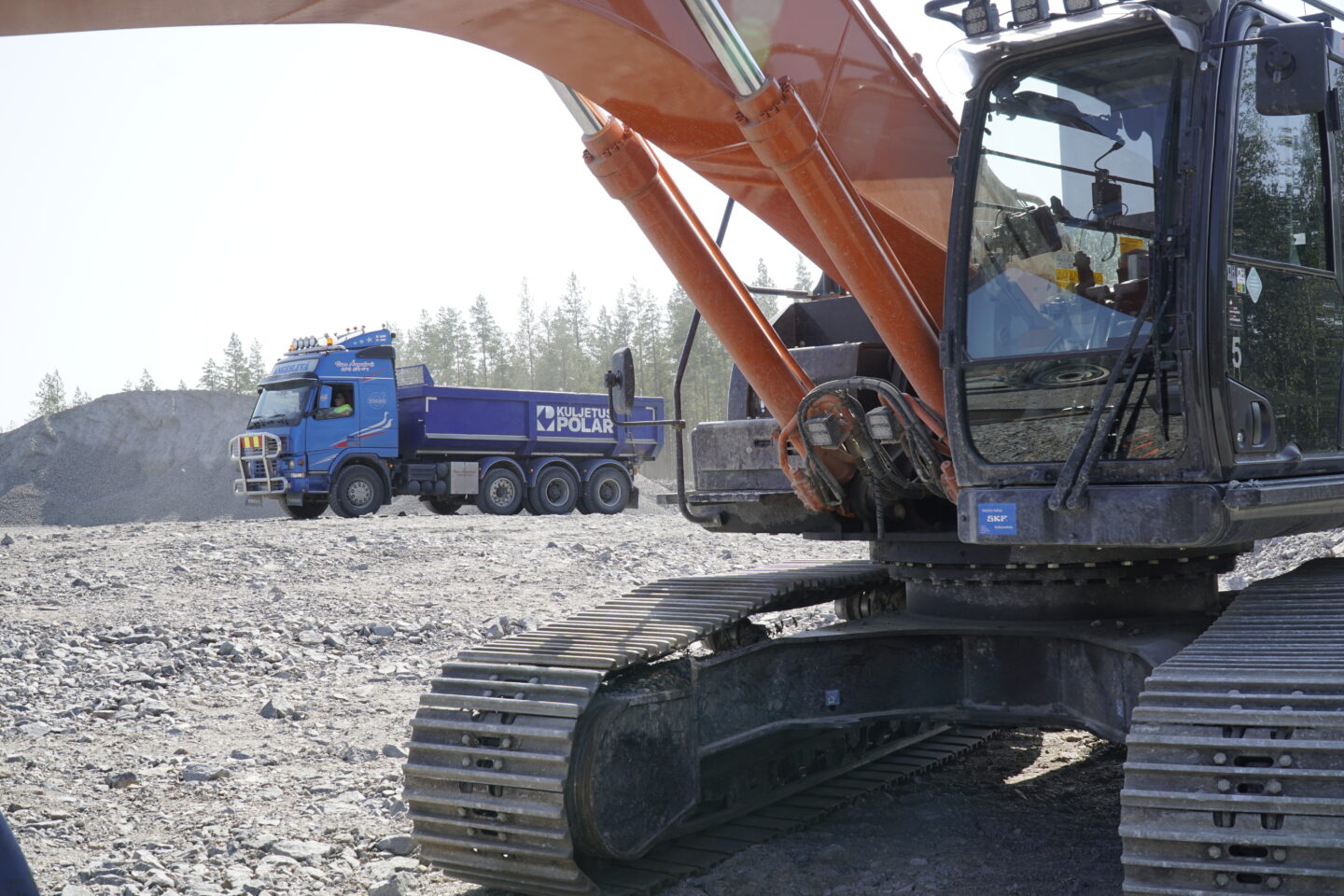 Sadevesijärjestelmä täytyy rakentaa huolellisesti. Lähikuvassa oranssi kaivinkone ja taustalla sininen kuorma-auto.